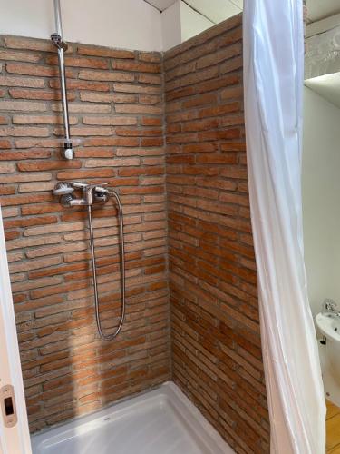 Marano MarchesatoIl Casale的带淋浴的浴室,浴室设有砖墙