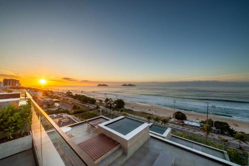 里约热内卢Lifestyle Laghetto Collection的享有日落海滩美景的大楼