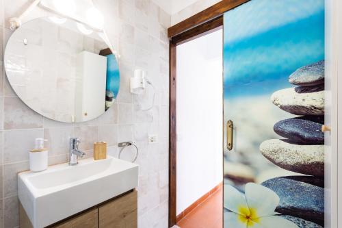 坎德拉里亚EK El Risco Candelaria的浴室设有水槽、镜子和一堆岩石