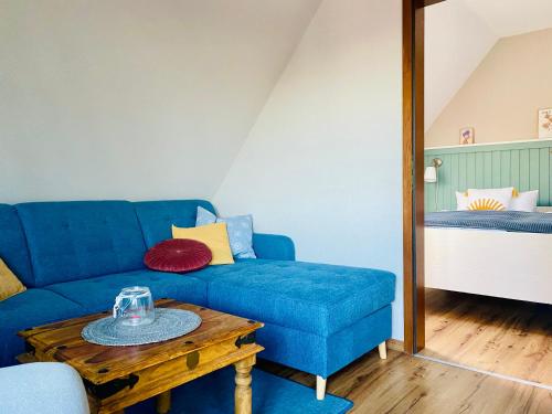 费马恩Kajüthus Apartment 1的客厅配有蓝色的沙发和桌子