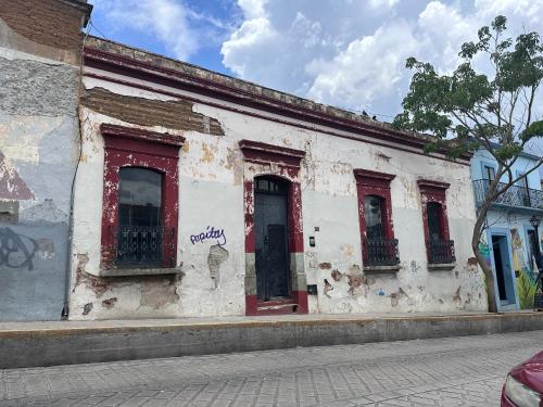 瓦哈卡市CASA PENUMBRA- Centro Oaxaca的一条旧白色的建筑,在街上有红色的窗户