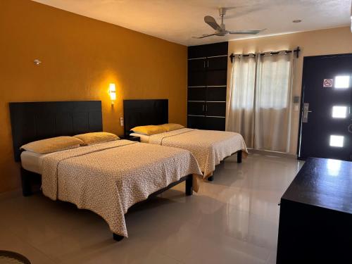 巴利亚多利德阿维拉酒店的黄色墙壁客房的两张床