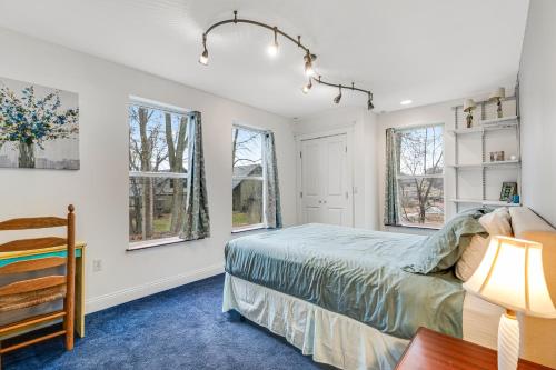 科尔切斯特The Artist's Lakeside Hideaway的一间卧室设有一张床和两个窗户。