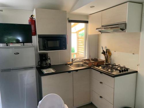 乌伊斯特勒昂Mobil-home Ouistreham的小厨房配有白色冰箱和水槽