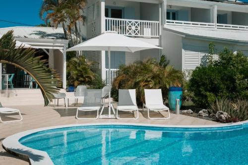 圣弗朗索瓦阿茂多酒店的房屋旁的游泳池配有椅子和遮阳伞