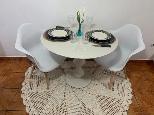 圣保罗Edícula tranquila e bem localizada no Butantã的一张带两把椅子的白色桌子和一张白色的桌布