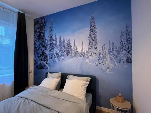 瓦朗西纳Suite Cosy MontBlanc en Hyper Centre的卧室拥有雪覆盖森林的壁画