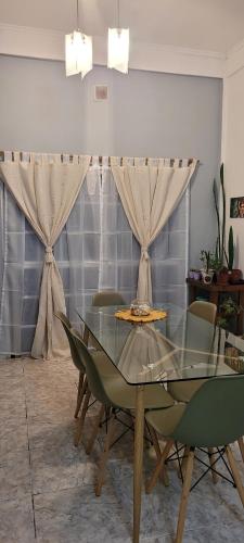 Barrio Esteban EcheverríaFinchu的一间设有玻璃桌和椅子的用餐室