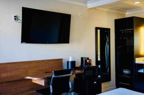 旧金山格林威治酒店的一间设有一张桌子和一台墙上的电视的房间