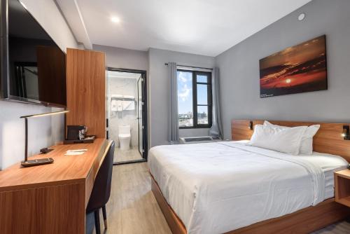 布鲁克林Liberty View Brooklyn Hotel的酒店客房配有一张床、一张书桌和一张书桌。