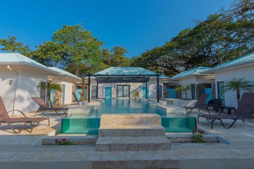 阿维拉纳海滩Villas VR Beachwalk Avellanas的一座带游泳池和一些椅子的房子