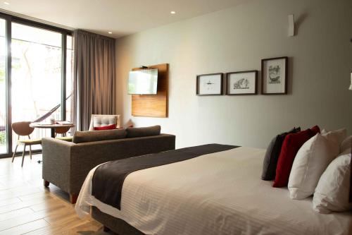 瓦哈卡市埃卡莱洪精品酒店的一间卧室配有一张床、一张沙发和一把椅子