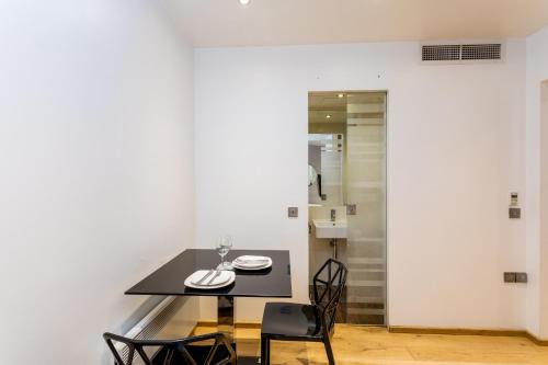 伦敦太空公寓的一间用餐室,配有黑色的桌子和椅子