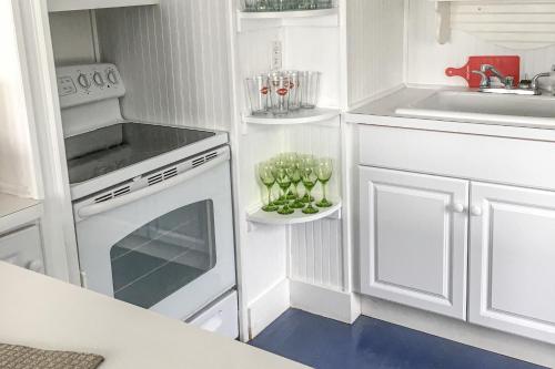 Cherry GroveCherry Grove Enchantment的厨房配有白色橱柜和白色炉灶烤箱。