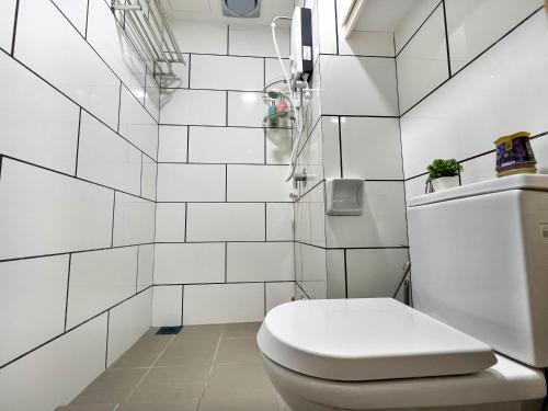 太平Modern Muji Home Retreat near Taiping Lake Garden with Free Netflix的浴室铺有白色瓷砖,设有白色卫生间。