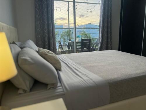 里奥阿托Beach-Style Pool Villa Paradise的一间卧室设有一张床,享有阳台的景色