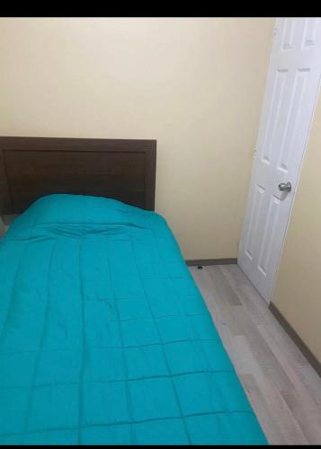 马查利Habitación con baño privado的一间卧室配有一张带蓝色床罩的床