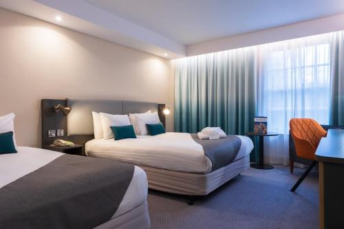 唐克斯特唐克斯特假日酒店的酒店客房设有两张床和窗户。