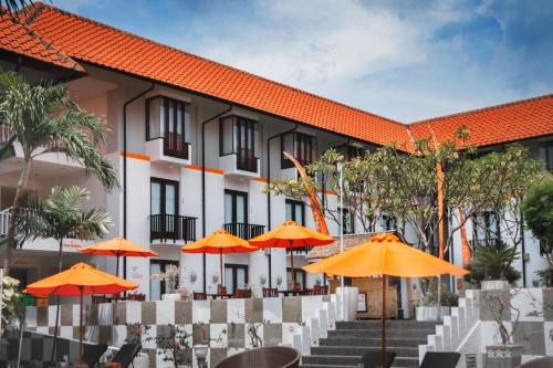 库塔HARRIS Hotel Kuta Tuban Bali的橙色遮阳伞的酒店外景
