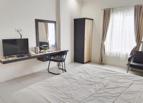 武吉丁宜KHARIZ HOTEL的一间卧室配有一张床、一张书桌和一面镜子