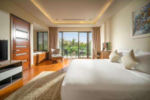 岘港Blue Ocean Villas Danang的卧室配有一张白色大床和电视。