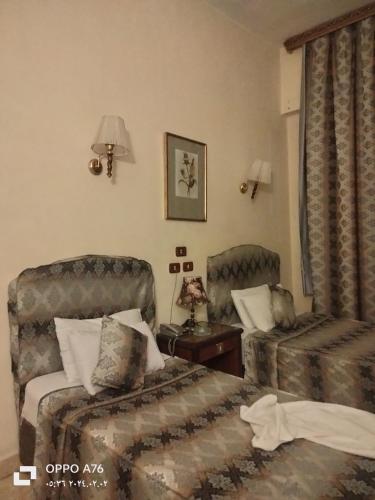 开罗Anubis Hostel的酒店客房,配有两张床和椅子