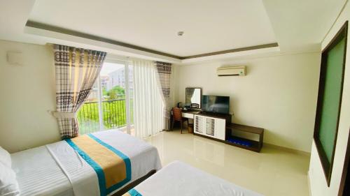 富国May Hotel Sonasea Phu Quoc的一间卧室设有一张床,阳台配有电视。