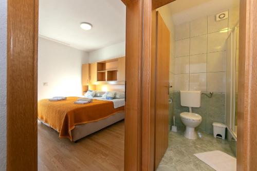 布雷拉Apartments Marko - amazing sea view的一间卧室配有一张床,浴室设有卫生间