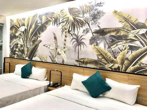 下龙湾Milash Boutique Hotel的棕榈树壁画客房的两张床