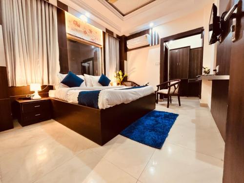 哈里瓦Hotel Rama, Top Rated and Most Awarded Property In Haridwar的一间卧室配有一张大床和蓝色地毯。
