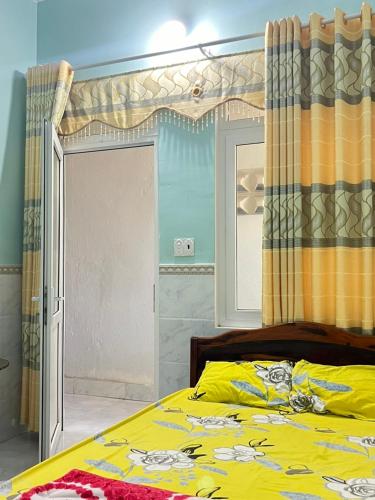 广义Homestay Xuân Mai的一间卧室配有一张黄色的床和窗帘