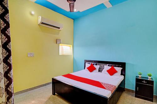 JhājharOYO Flagship Midtown Guesthouse的一间卧室设有一张红色和绿色的墙壁。