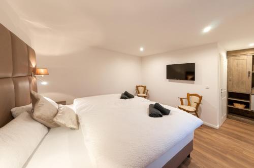 勒讷Landgasthaus Krimpenfort的卧室配有白色的床和平面电视。