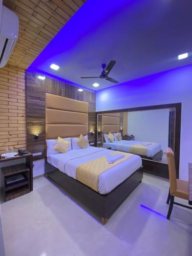孟买Hotel Blue Wellington - Near Mumbai Airport的卧室内的两张床,配有紫色照明