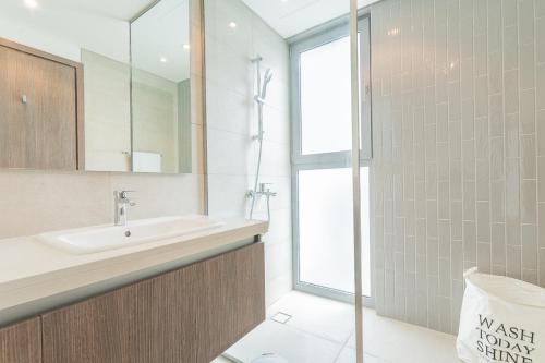 迪拜Cosy Luxury villa Tilal Alghaf的一间带水槽和玻璃淋浴的浴室