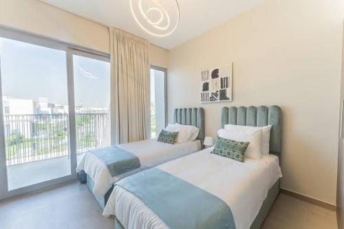 迪拜Cosy Luxury villa Tilal Alghaf的卧室设有两张床和大窗户