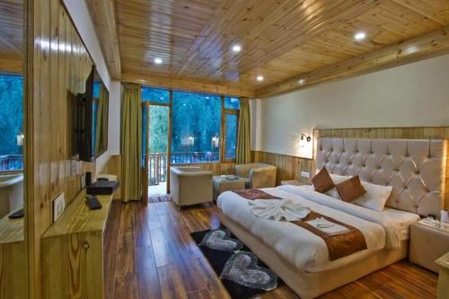 马拉里Himalayan Riverside Resort, Manali的一间卧室设有一张大床和一个大窗户