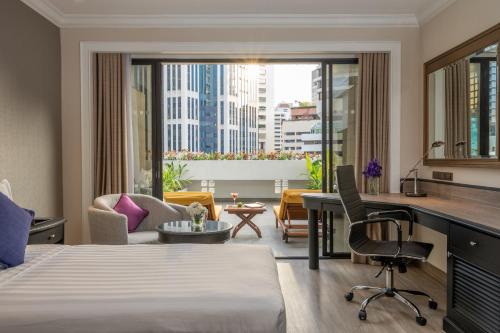 曼谷曼谷素坤逸大道酒店的配有一张床和一张书桌的酒店客房