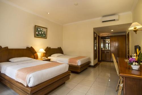 沙努尔帕瑞吉塔度假酒店及水疗中心的酒店客房配有两张床和一张书桌