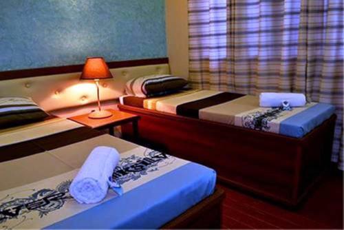 公主港朱丽叶宾馆的一间卧室配有两张床和一张带台灯的桌子