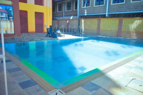 纳纽基Balozi Luxury Homes的大楼内一个蓝色的大型游泳池