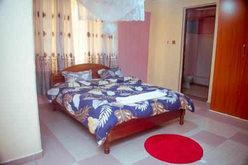 纳纽基Balozi Luxury Homes的一间卧室配有一张带蓝色棉被的床