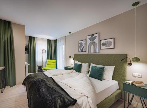 瓦尔道拉公园精品酒店 的一间卧室配有一张大床和绿色床头板