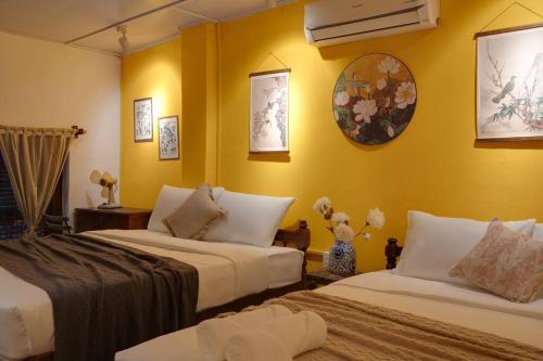 胡志明市Ben Thanh_Unique Vietnamese cultural house_Bathtub的黄色墙壁客房的两张床