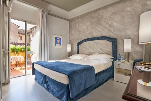 佛罗伦萨里沃利精品酒店的一间卧室配有一张带蓝色毯子的床