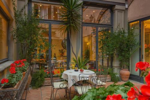 佛罗伦萨里沃利精品酒店的庭院配有桌椅和鲜花