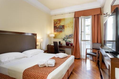 佛罗伦萨亚德里亚海大酒店的配有一张床和一张书桌的酒店客房