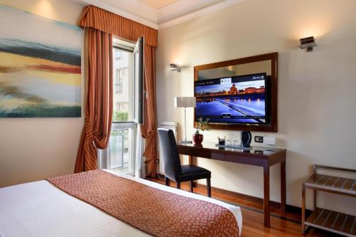 佛罗伦萨亚德里亚海大酒店的酒店客房设有一张床、一张书桌和一台电视机。