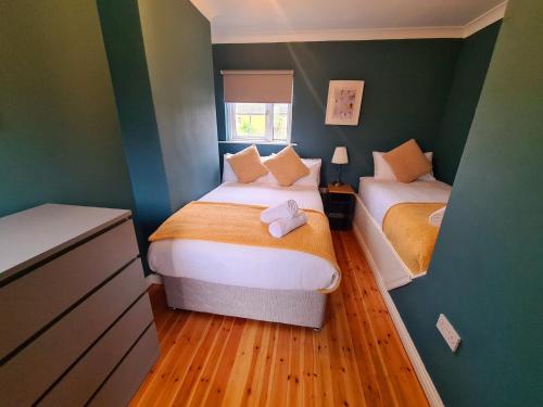 戈尔韦Stylish 3 Bedroom Galway House的小型客房 - 带两张床和绿色墙壁