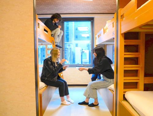 东京COGO Ryogoku的两位女士坐在房间里双层床上